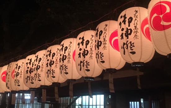 Japanese paper lanterns glowing on a dark evening at a local summer festival
